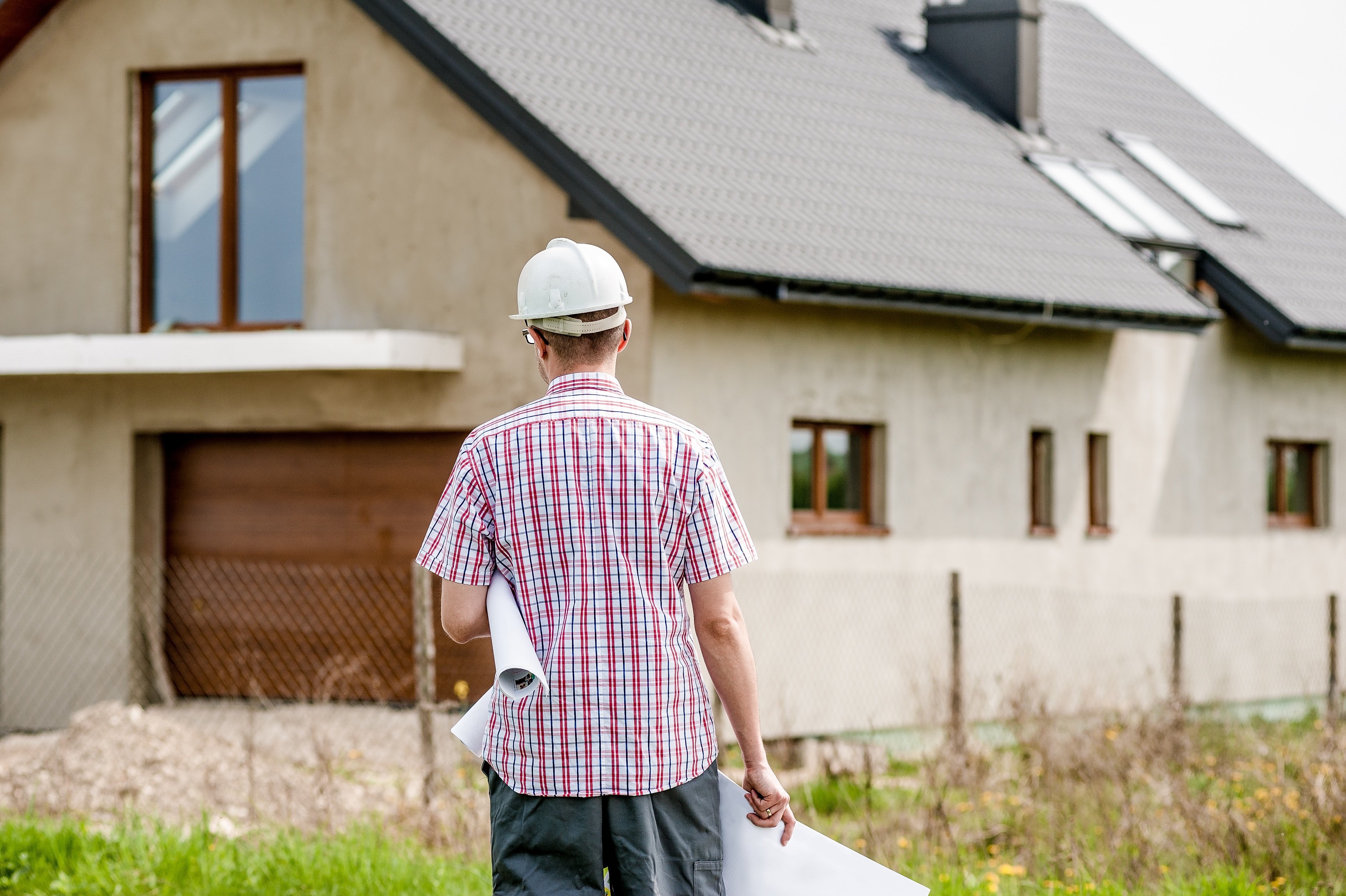 Baupläne und Schutzhelm für Hausbau- und Hauskauf-Finanzierung